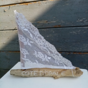 Petit bateau en bois flotté avec une voile en véritable dentelle de Calais. Une inscription " Côte d'Opale" faite avec un outil de pointage d'art et peinture blanche