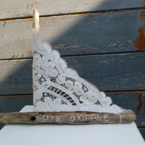 Petit bateau en bois flotté avec une voile faite dans un napperon ancien. Une inscription " Côte d'Opale" a été faire sur le bois avec un outils de pointage d'art couleur blanc