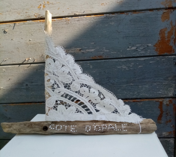 Petit bateau en bois flotté avec une voile faite dans un napperon ancien. Une inscription " Côte d'Opale" a été faire sur le bois avec un outils de pointage d'art couleur blanc